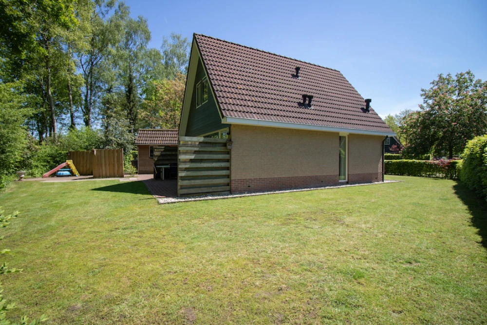 Tuin van Simmelink – terras met zitplekken in een ruime bostuin, midden in de bosrijke natuur.