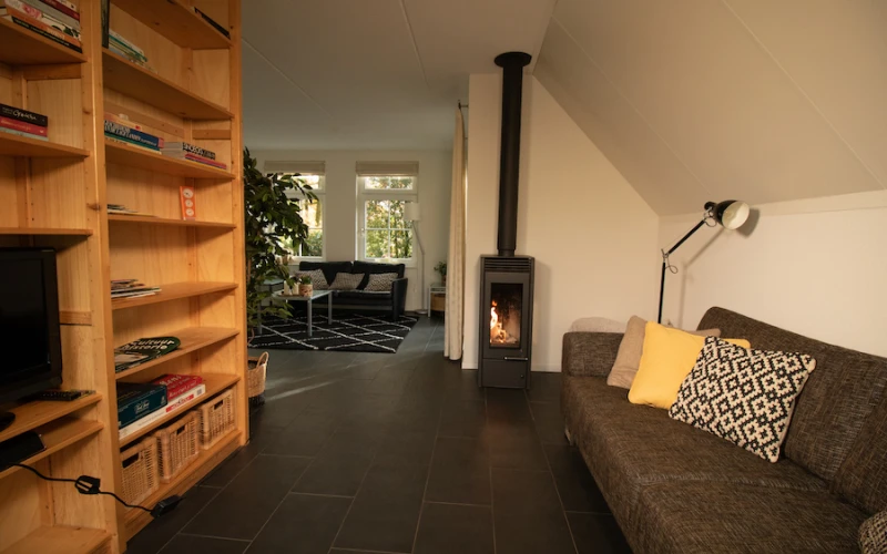 Woonkamer van Aurora – sfeervolle zithoek met houtkachel, prachtige ligging, privacy, met uitzicht op het groen.