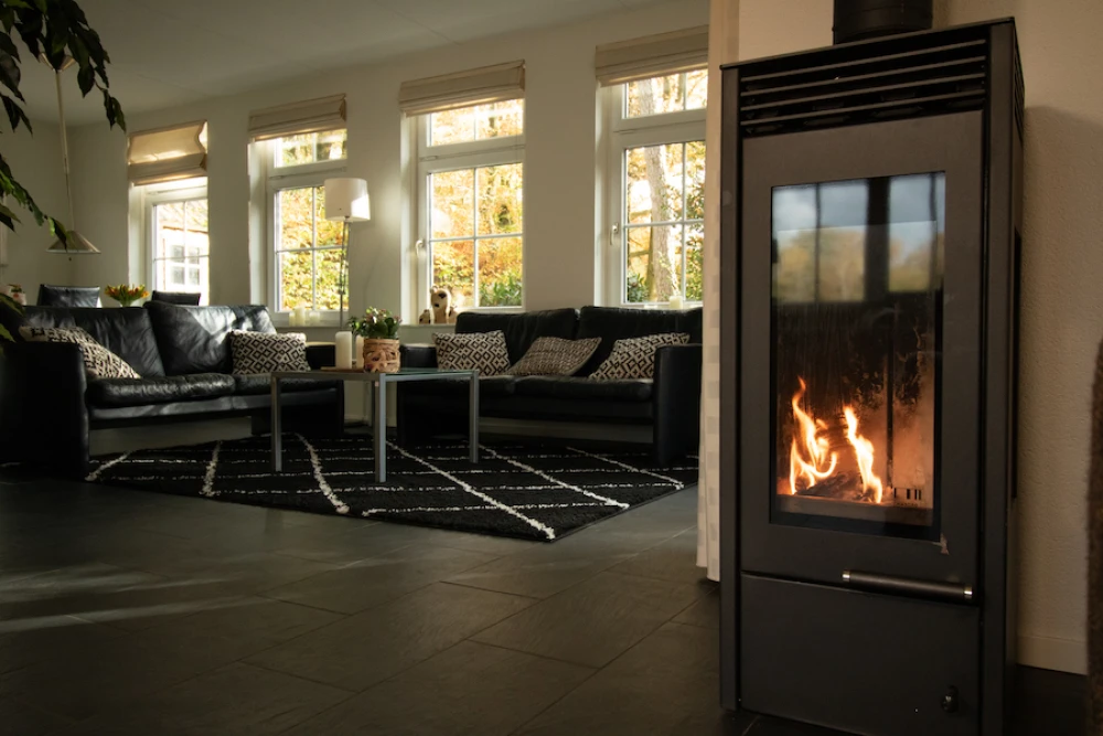 Woonkamer van Aurora – sfeervolle zithoek met houtkachel, prachtige ligging, privacy, met uitzicht op het groen.