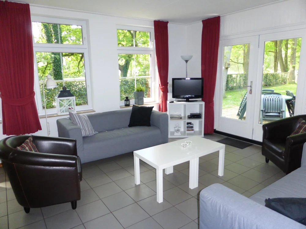 Woonkamer van Stoverink – sfeervolle zithoek met mindervalide, omheinde tuin, prachtige ligging, privacy, met uitzicht op het groen. Huisdieren welkom.