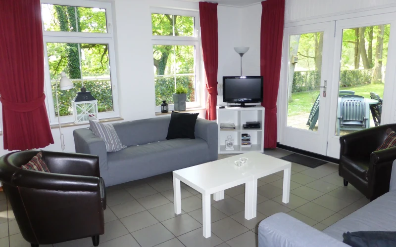 Woonkamer van Stoverink – sfeervolle zithoek met mindervalide, omheinde tuin, prachtige ligging, privacy, met uitzicht op het groen. Huisdieren welkom.