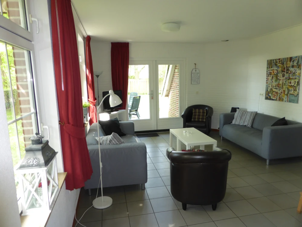 Woonkamer van Stoverink – sfeervolle zithoek met mindervalide, omheinde tuin, prachtige ligging, privacy, met uitzicht op het groen. Huisdieren welkom.