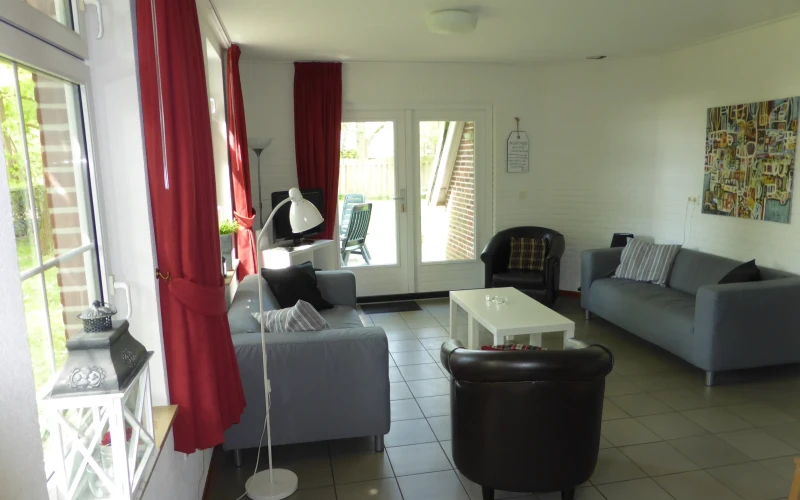 Woonkamer van Stoverink – sfeervolle zithoek met mindervalide, omheinde tuin, prachtige ligging, privacy, met uitzicht op het groen. Huisdieren welkom.