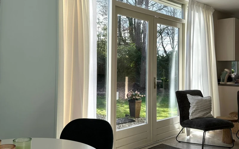 Woonkamer van Libelle – sfeervolle zithoek met huisdieren welkom!, omheinde tuin, prachtige ligging, privacy, sauna, tuinkamer, twee badkamers, met uitzicht op het groen. Huisdieren welkom.